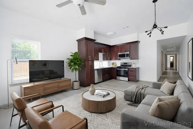 a living room with stainless steel appliances kitchen island granite countertop furniture and a flat screen tv