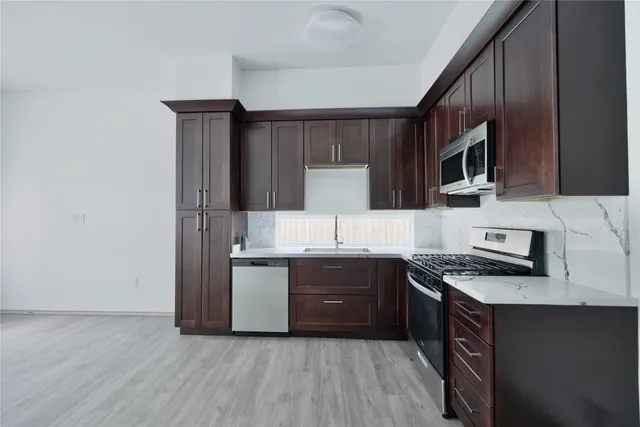 a kitchen with stainless steel appliances granite countertop a sink stove and refrigerator