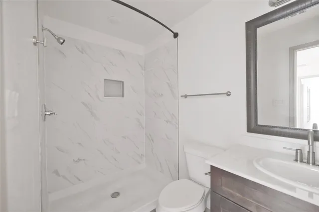 a bathroom with a bathtub shower sink vanity and toilet