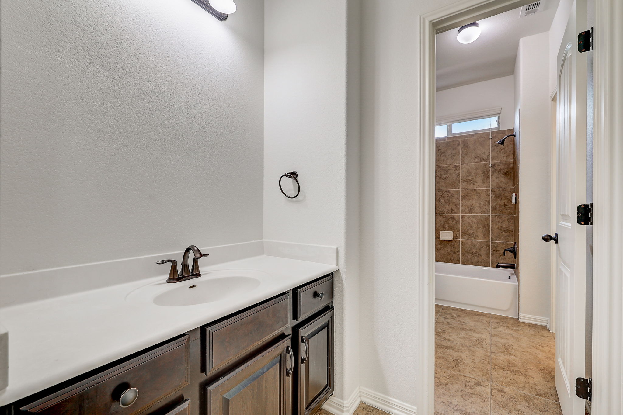 16012 Spillman Ranch Loop Austin, TX 78738 - Photo 26 of 38 A streamlined vanity with dark cabinetry offers practical storage and a crisp, clean aesthetic.