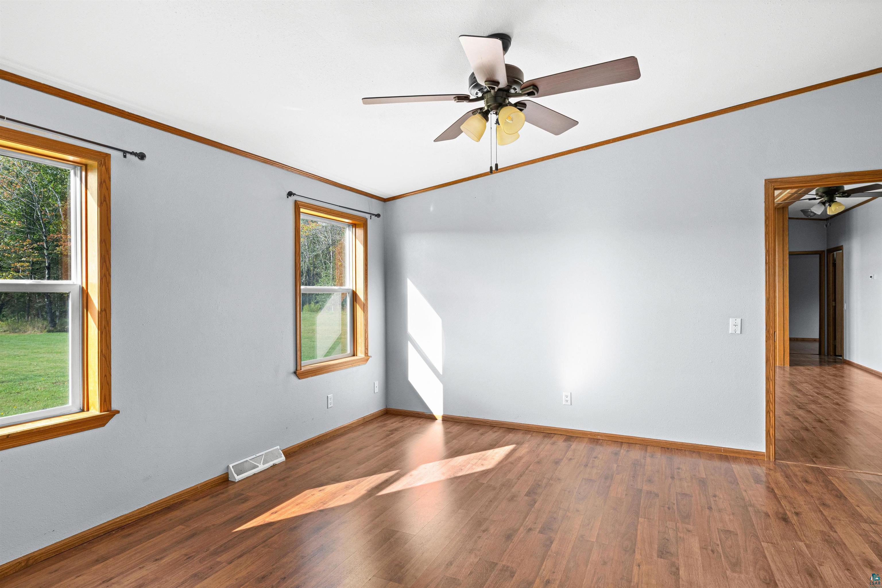 3126 Beyer Road Duluth, MN 55804 - Photo 17 of 23 Light-filled room featuring laminate flooring, two large windows and a ceiling fan with integrated lighting