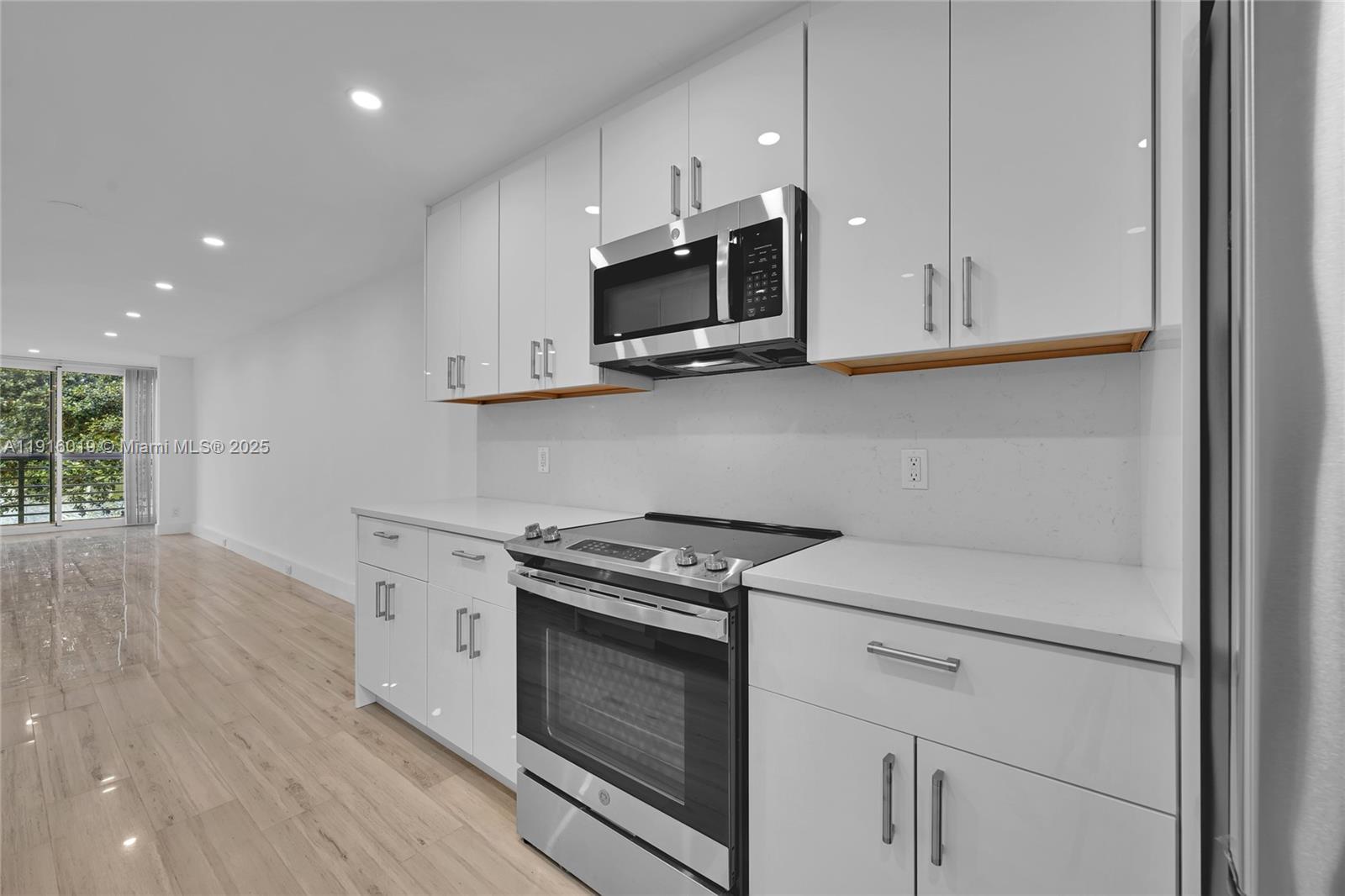 a kitchen with stainless steel appliances granite countertop white cabinets and a stove top oven