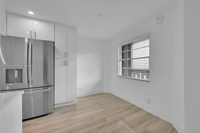 a view of a kitchen with a refrigerator cabinet and a window