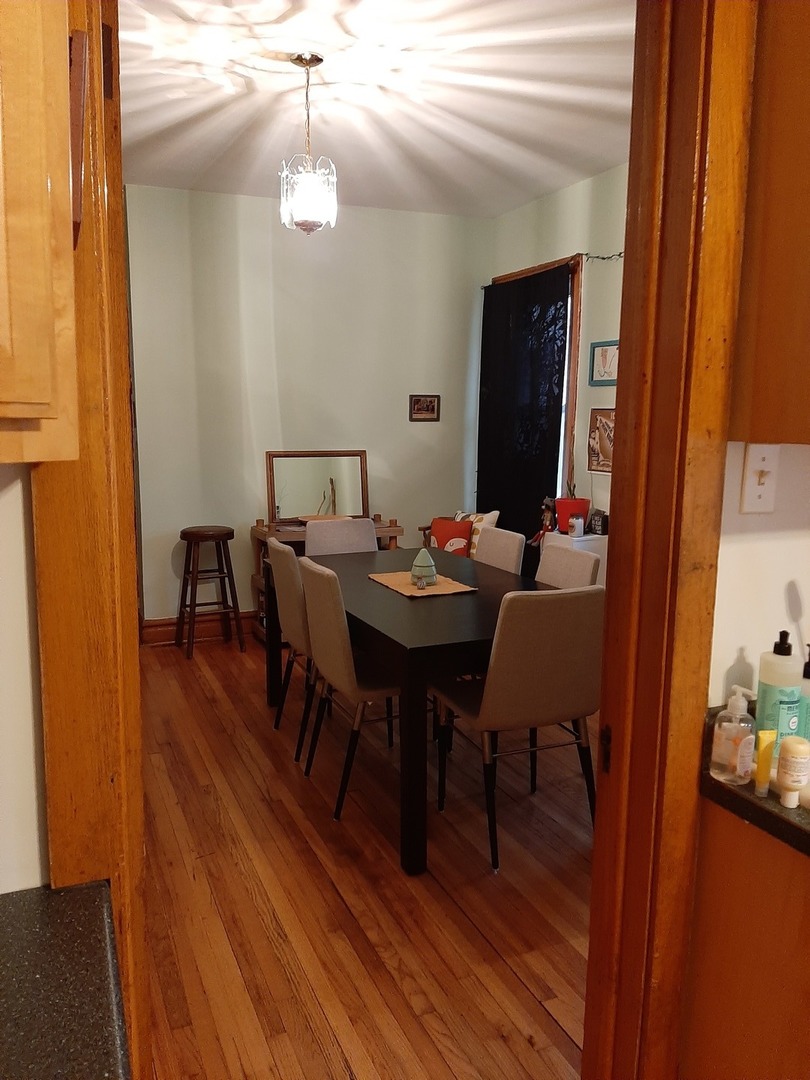 3142 South Morgan Street Chicago, IL 60608 - Photo 10 of 22 a dining room with furniture wooden floor and a chandelier