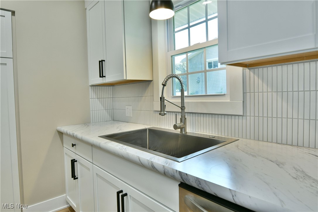 7655 Connelly Road Masury, OH 44438 - Photo 10 of 46 Kitchen with tasteful backsplash, white cabinetry, and light stone countertops