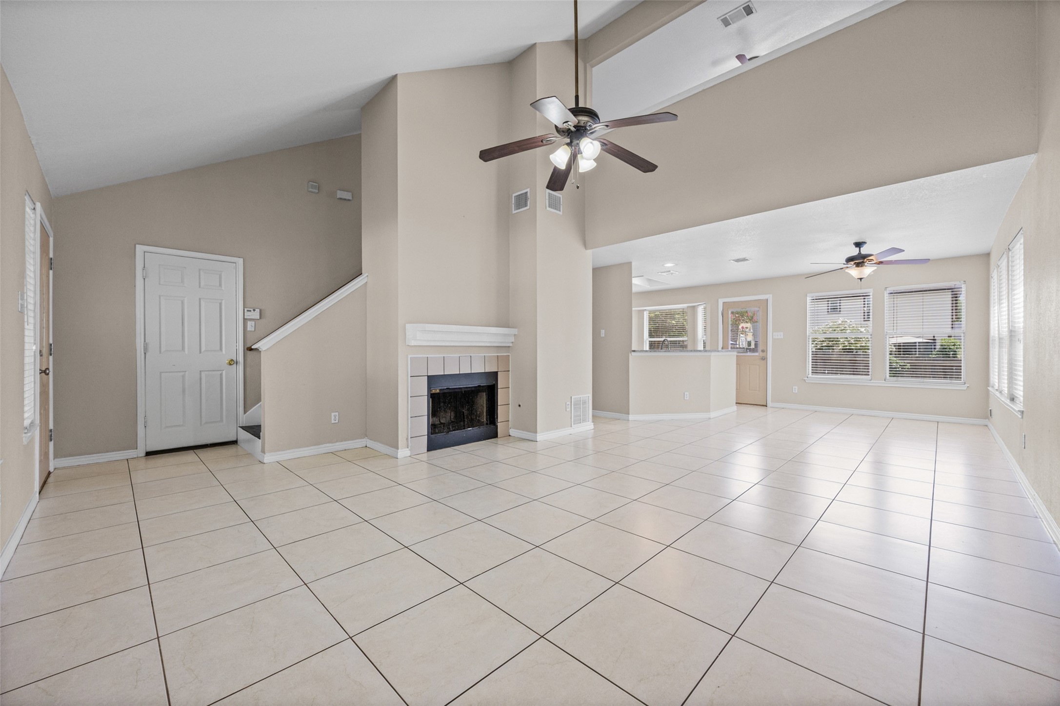 2432 Roundabout Lane Round Rock, TX 78664 - Photo 4 of 22 Vast tile flooring stretches across an open-concept living space, illuminated by abundant windows and vaulted ceilings.