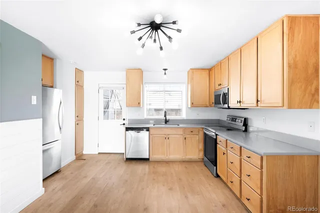a large kitchen with a large window a sink and stainless steel appliances