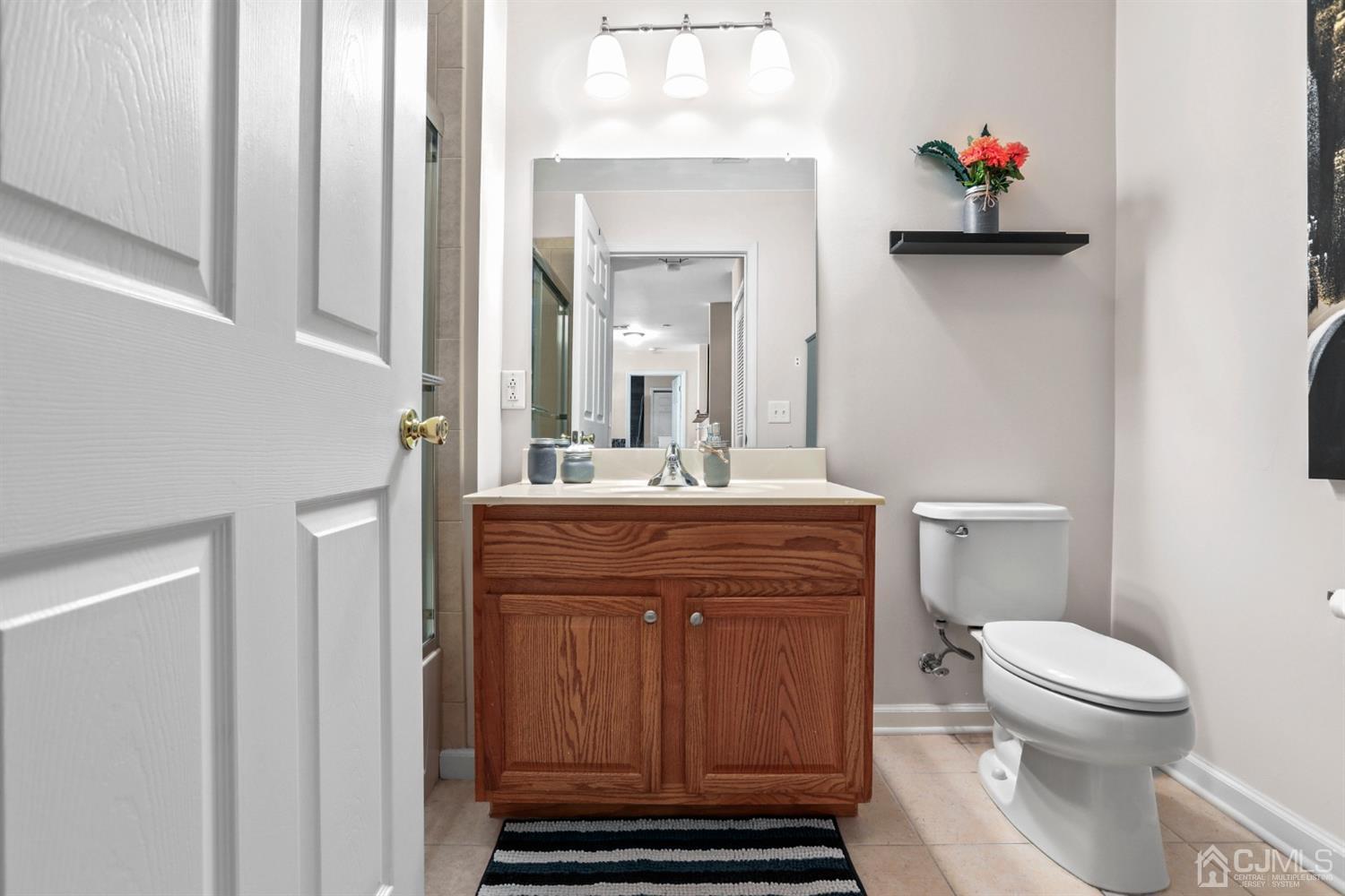 358 Rector Street, Unit 706 Perth Amboy, NJ 08861 - Photo 12 of 20 a bathroom with a sink a toilet and a mirror