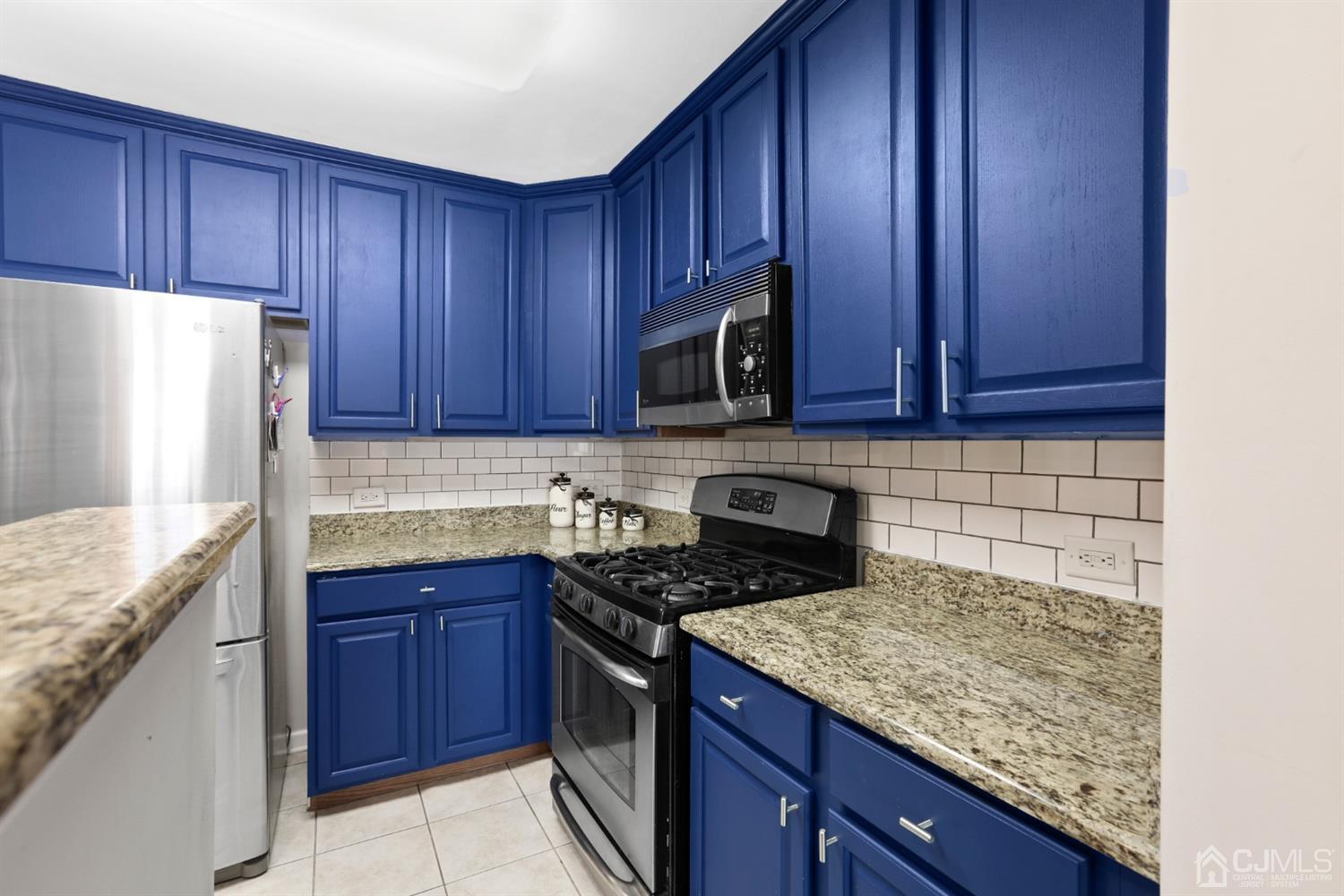 358 Rector Street, Unit 706 Perth Amboy, NJ 08861 - Photo 5 of 20 a kitchen with granite countertop wooden cabinets and a stainless steel appliances