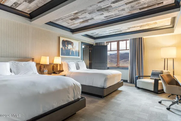 a bedroom with two beds and large window