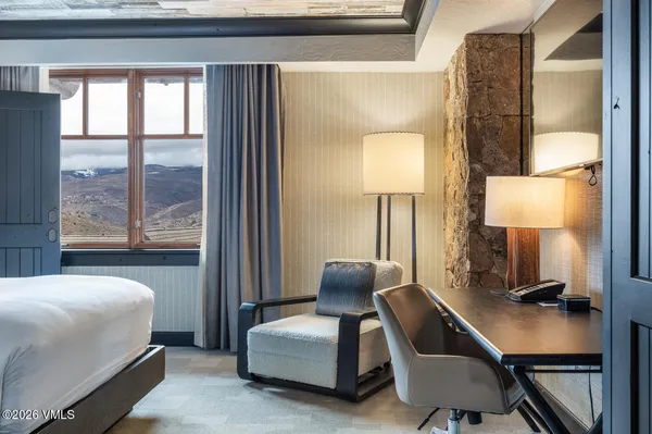 a bedroom with furniture and a lamp