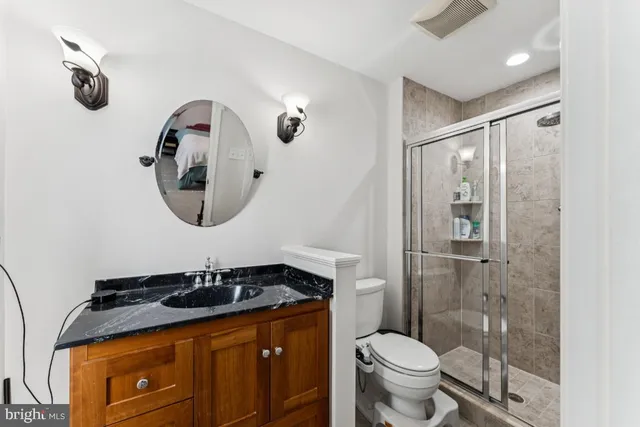 a bathroom with a sink a toilet and shower