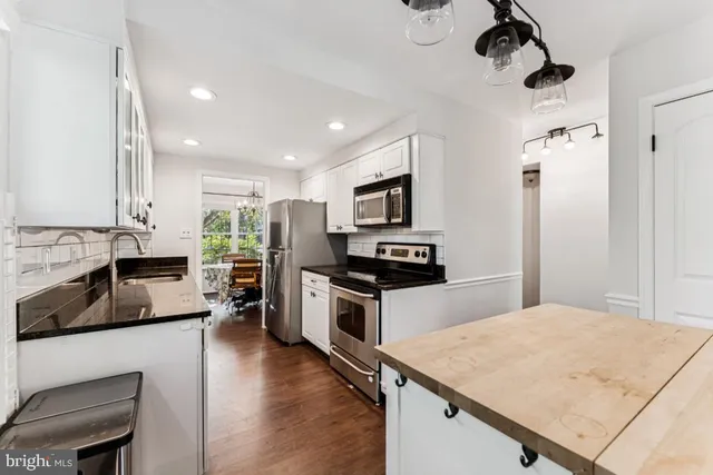 a kitchen with a refrigerator a stove top oven a sink dishwasher and wooden cabinets