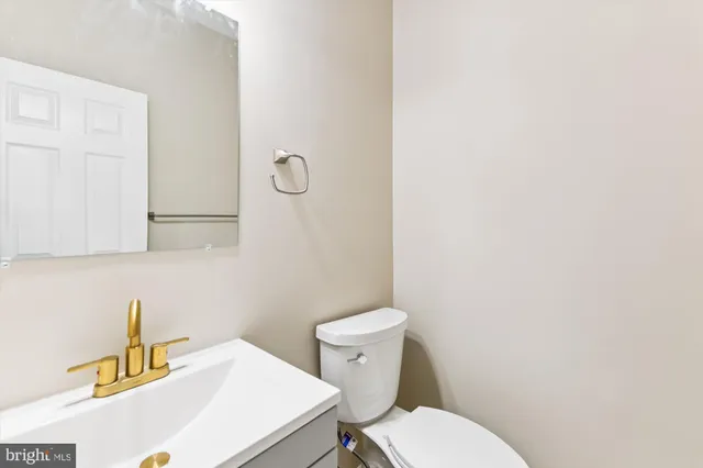 a bathroom with a sink a toilet and a mirror