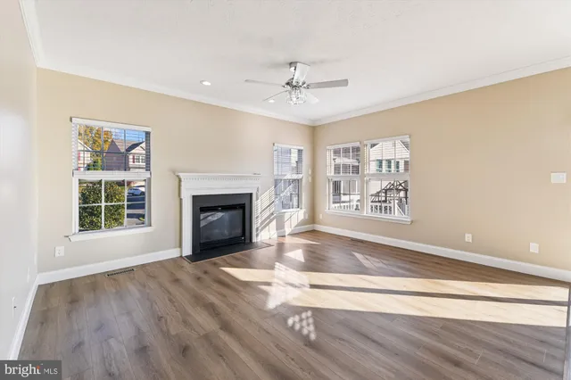 a view of an empty room with a window and fireplace