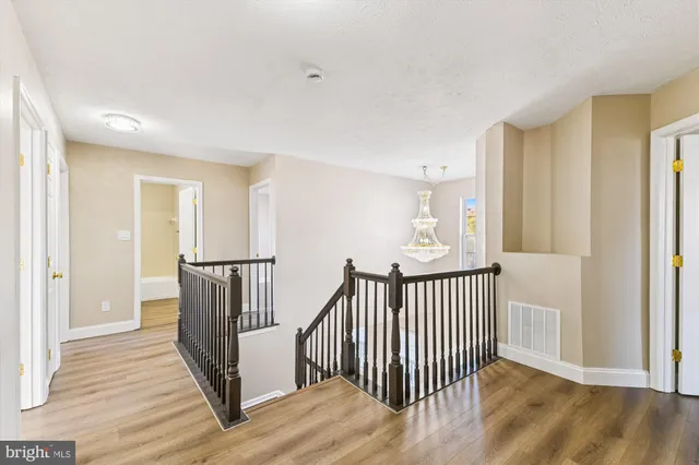 a view of a hallway with wooden floor and windows