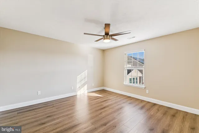 a view of wooden floor and a chandelier fan in a room