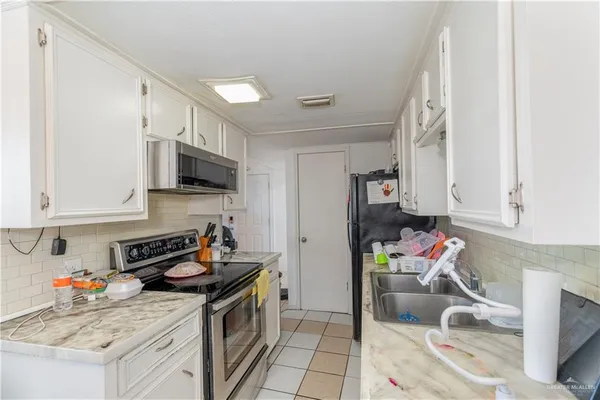 a kitchen with a sink a stove and cabinets