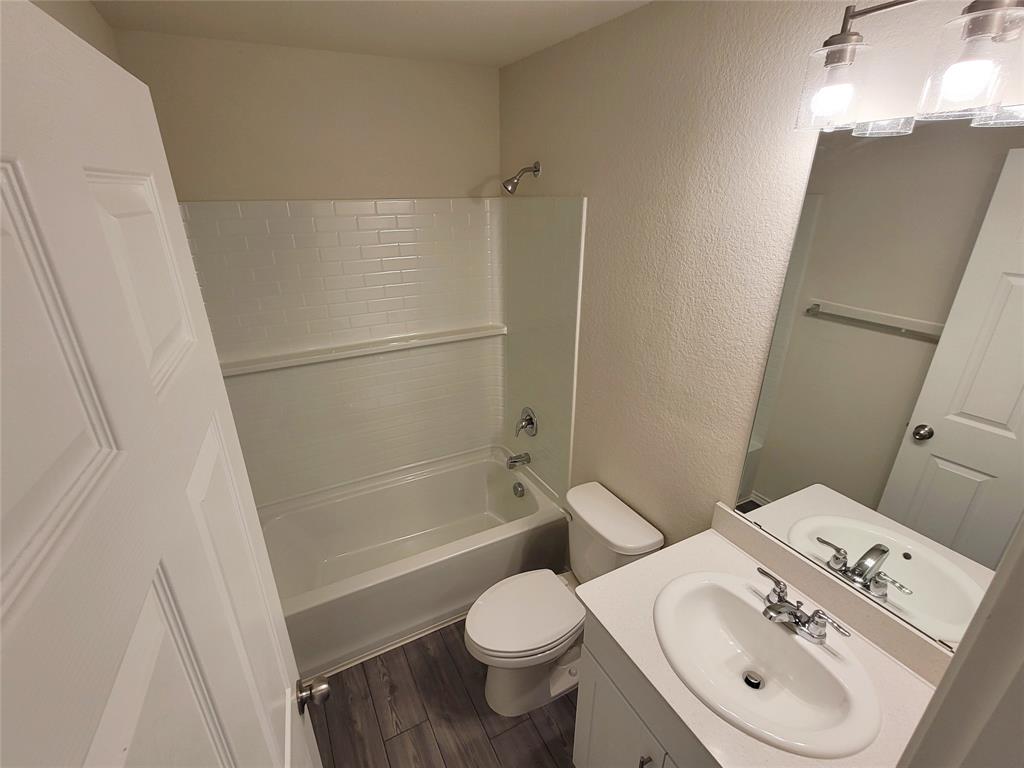 1049 Knightly Lane Haslet, TX 76052 - Photo 14 of 19 a white toilet sitting next to a bath tub