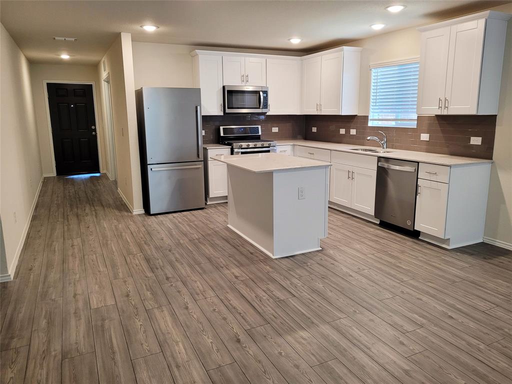 1049 Knightly Lane Haslet, TX 76052 - Photo 3 of 19 a kitchen with a refrigerator a sink and cabinets