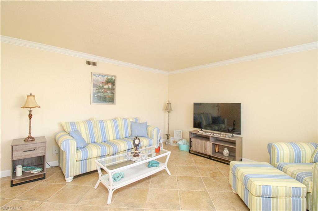 4615 Bayshore Drive, Unit E4 Naples, FL 34112 - Photo 12 of 30 a living room with furniture and a flat screen tv