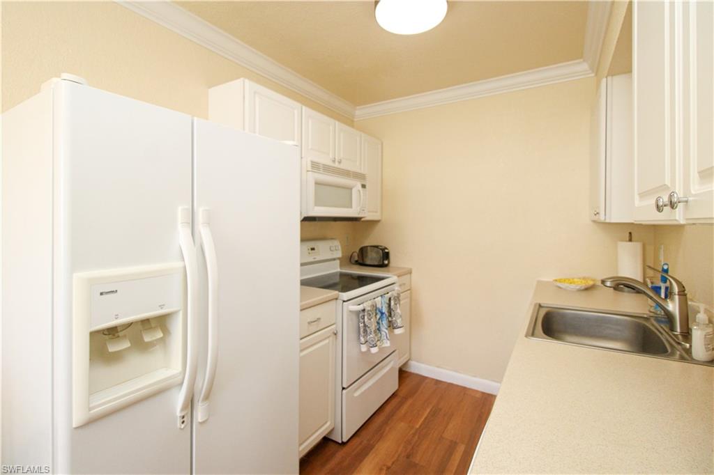 4615 Bayshore Drive, Unit E4 Naples, FL 34112 - Photo 14 of 30 a kitchen with a sink and a refrigerator