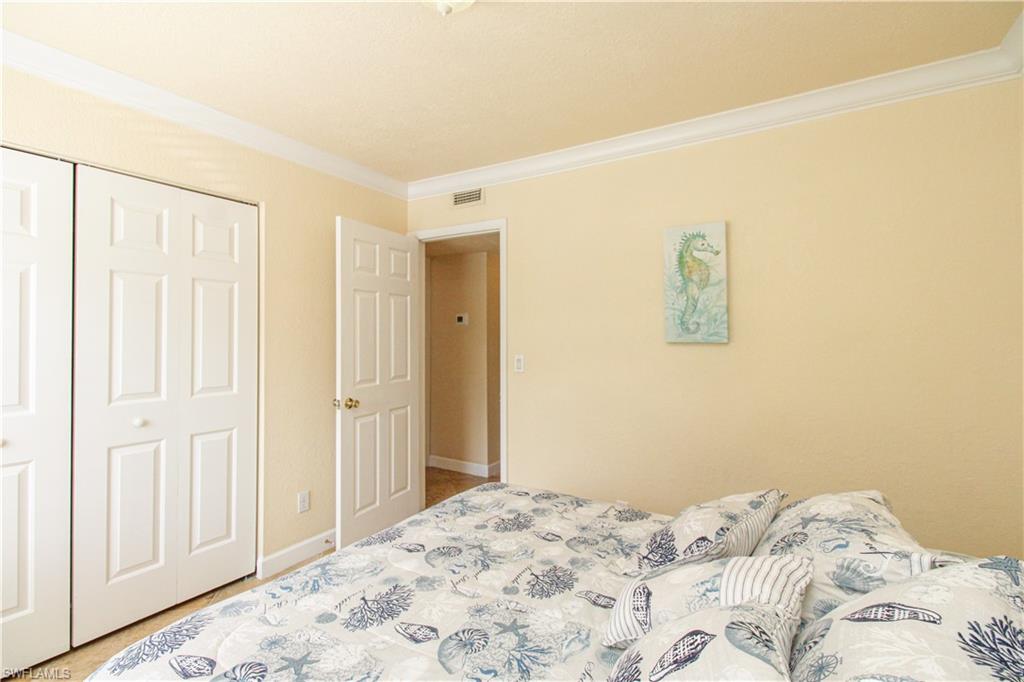 4615 Bayshore Drive, Unit E4 Naples, FL 34112 - Photo 23 of 30 a bedroom with a bed and a window