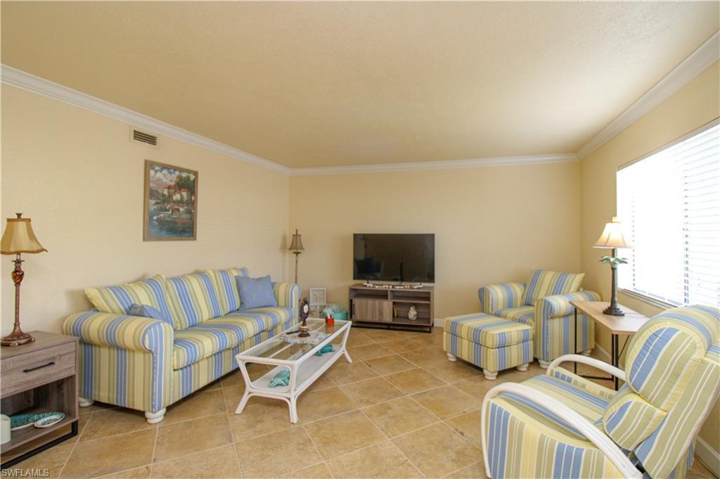 4615 Bayshore Drive, Unit E4 Naples, FL 34112 - Photo 7 of 30 a living room with furniture and a flat screen tv