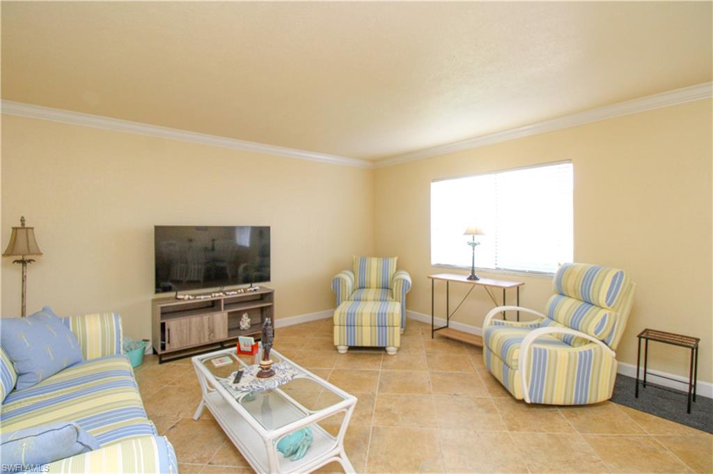 4615 Bayshore Drive, Unit E4 Naples, FL 34112 - Photo 9 of 30 a living room with furniture and a flat screen tv