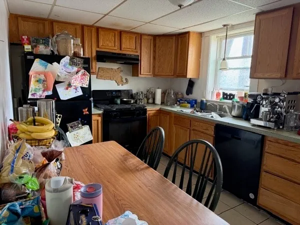 a kitchen with a sink a stove and chairs