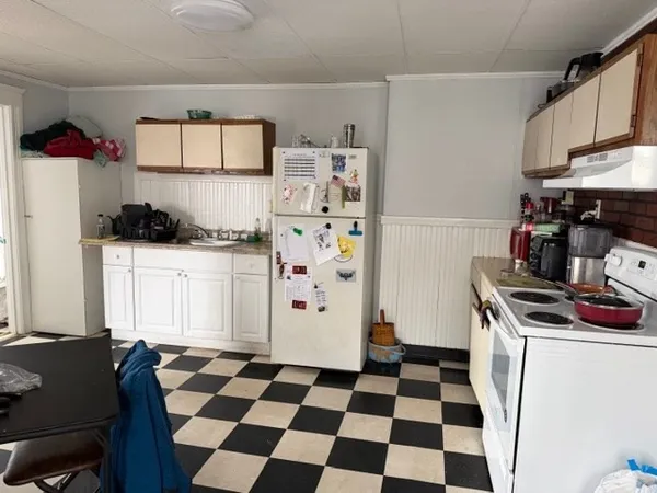 a kitchen with a stove a refrigerator and a cabinets