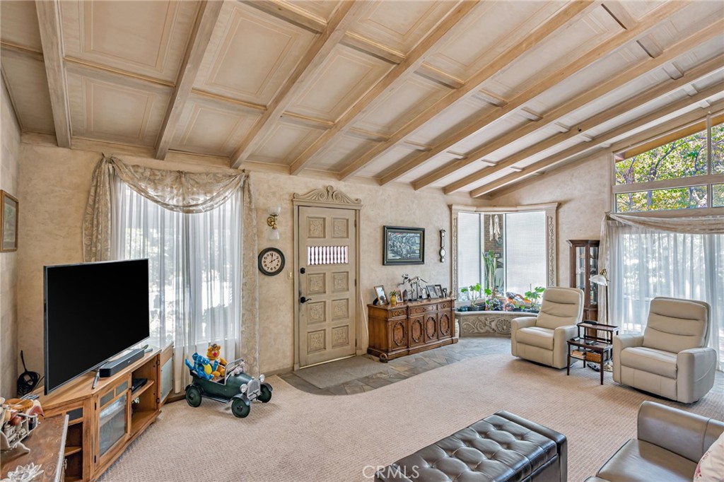 1126 Katherine Road Simi Valley, CA 93063 - Photo 11 of 66 a living room with furniture a flat screen tv and a floor to ceiling window