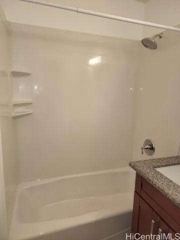 a bathroom with a granite countertop shower and a bathtub