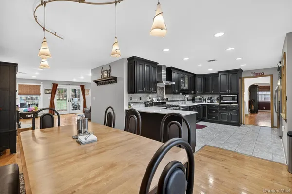 a kitchen with stainless steel appliances granite countertop a table and chairs