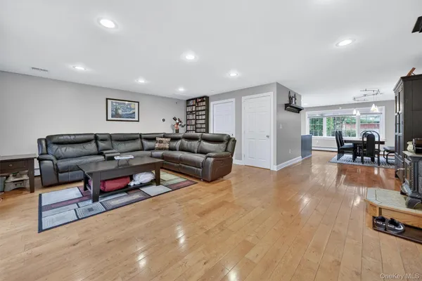 a living room with furniture and a dining table with wooden floor