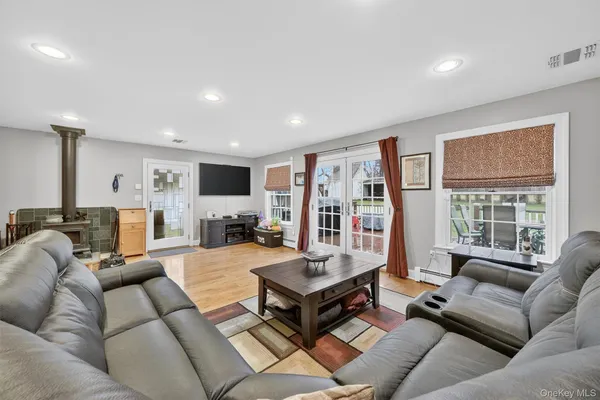 a living room with furniture a flat screen tv and a large window