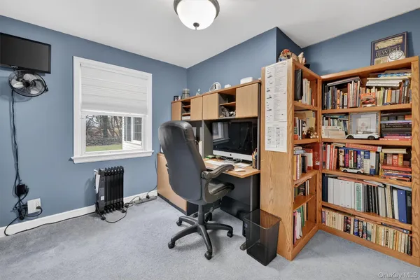 a view of a workspace with furniture and a bookshelf