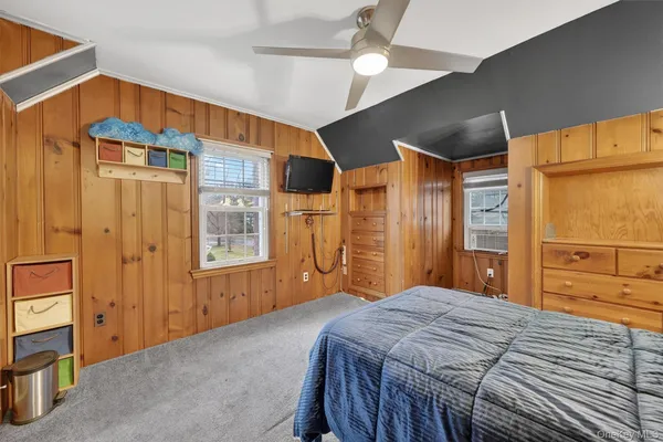 a bedroom with a large bed and large windows