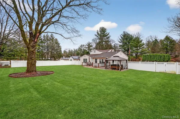 a view of a house with garden and a tree