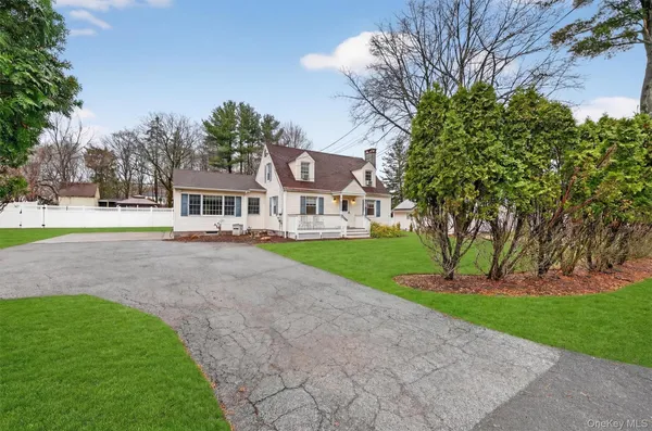 a front view of a house with garden and trees