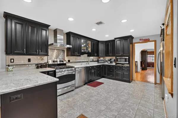 a kitchen with stainless steel appliances granite countertop a stove refrigerator sink and cabinets