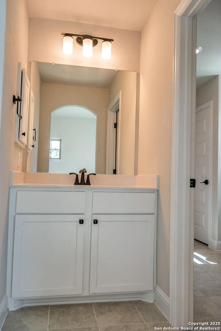 29354 Cheyenne Ridge Fair Oaks Ranch, TX 78015 - Photo 14 of 14 a bathroom with a sink vanity and a mirror