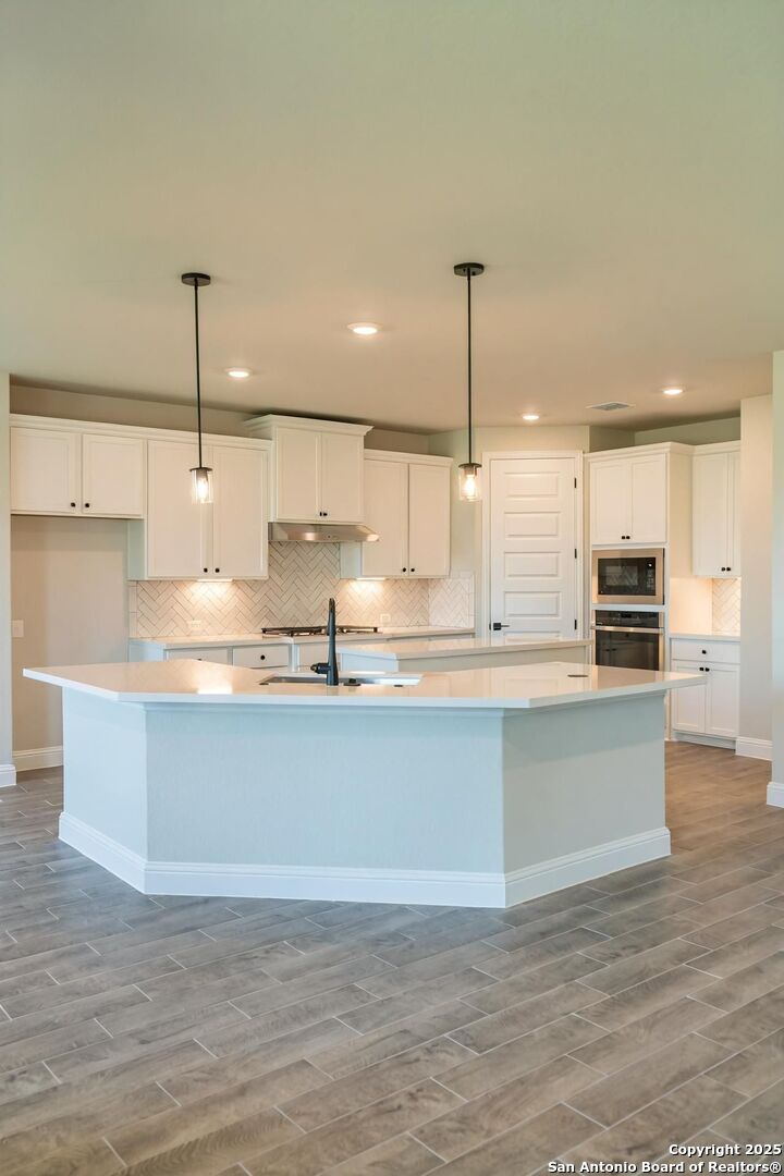 29354 Cheyenne Ridge Fair Oaks Ranch, TX 78015 - Photo 3 of 14 a large kitchen with kitchen island a large counter space a sink and appliances