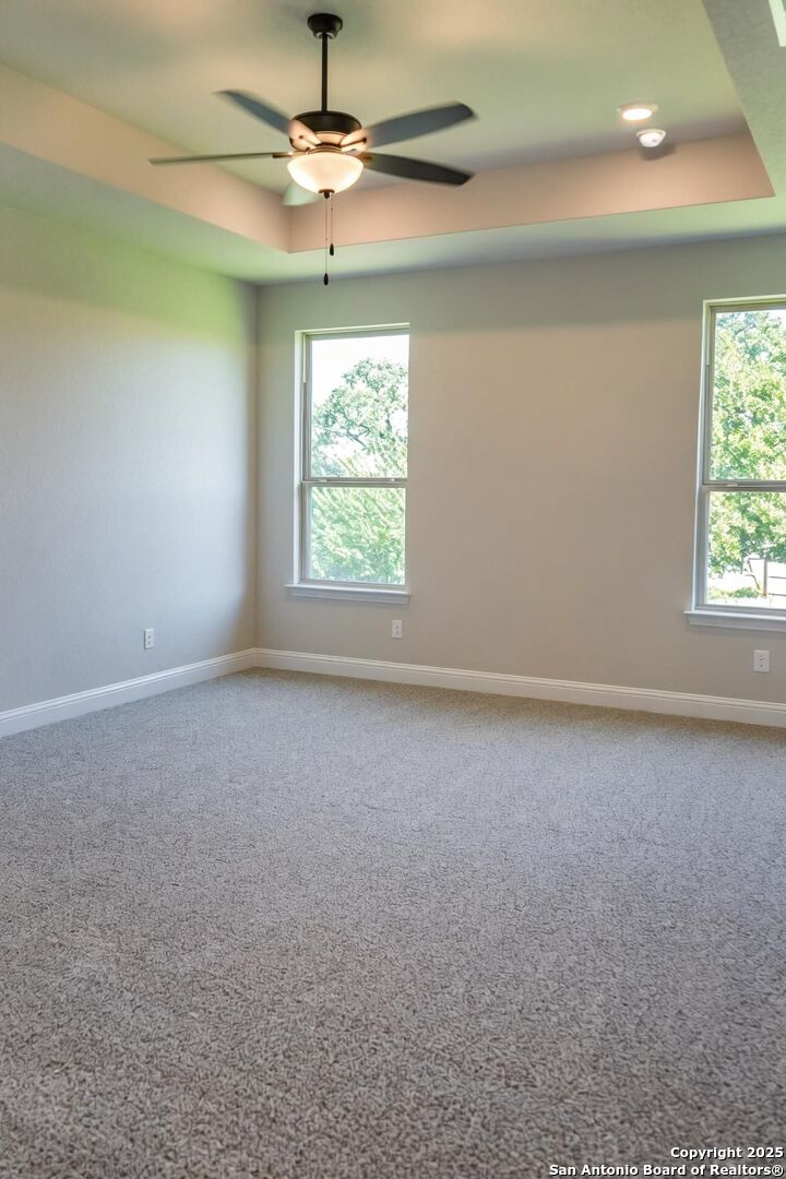 29354 Cheyenne Ridge Fair Oaks Ranch, TX 78015 - Photo 4 of 14 en empty room with windows and ceiling fan