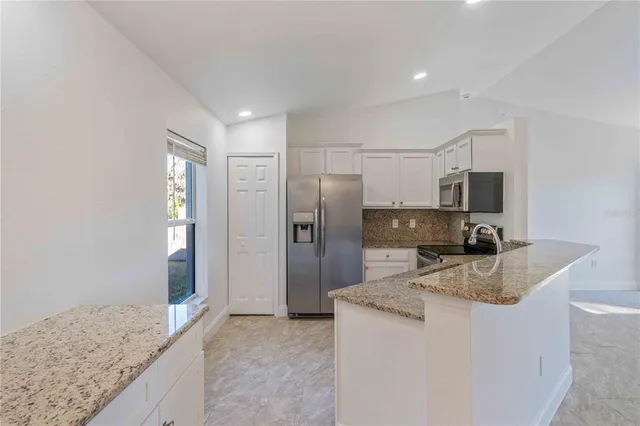 a kitchen with stainless steel appliances granite countertop a refrigerator and a sink