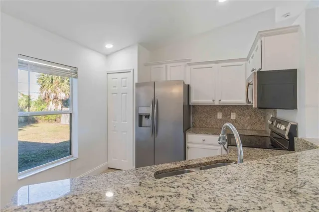 a kitchen with stainless steel appliances granite countertop a refrigerator and a sink