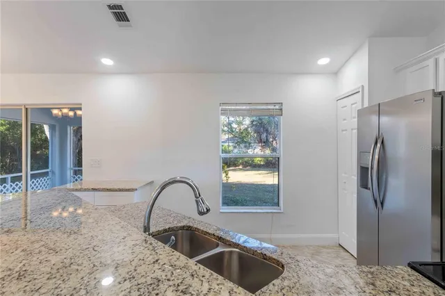 a kitchen with granite countertop a sink and cabinets