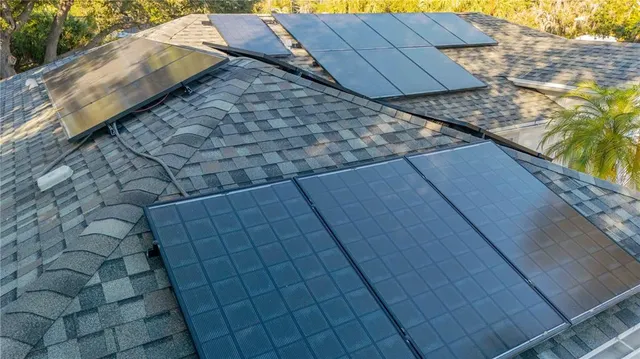 a view of a house with a yard and large trees