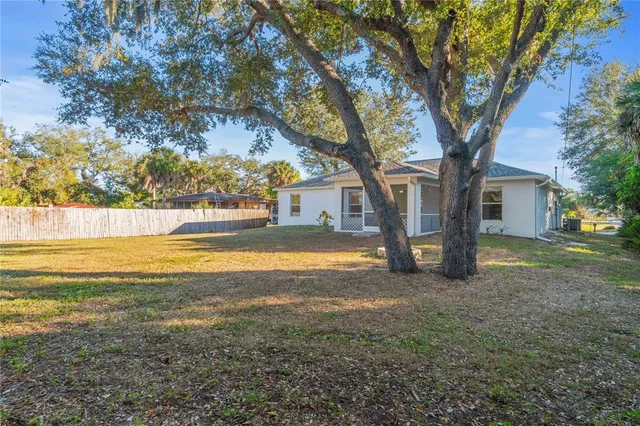a view of a yard with plants and trees