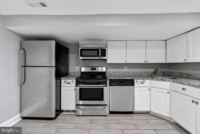 a kitchen with stainless steel appliances granite countertop a stove a refrigerator and a granite counter tops